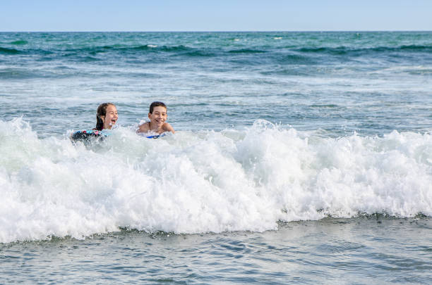 istock Young kids with small surfboard at the beach 1170419850