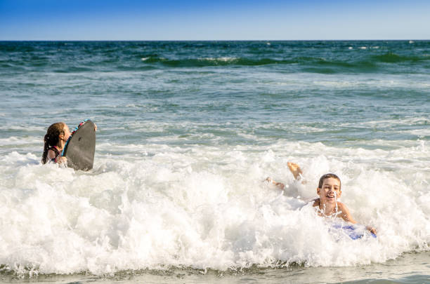 istock Young kids with small surfboard at the beach 1170419905