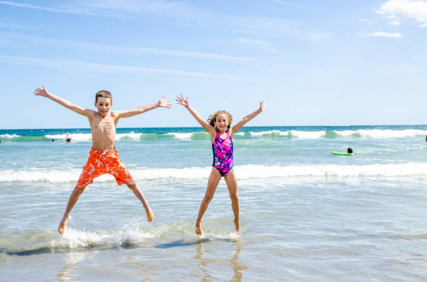 istock Kids jumping in the air at the beach 1170419925