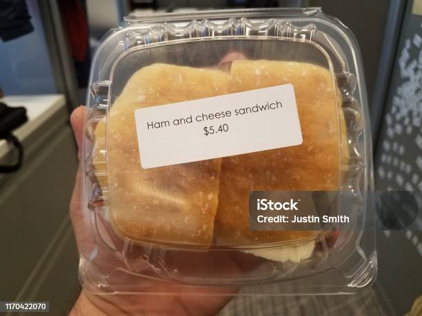 https://media.istockphoto.com/id/1170422070/photo/hand-holding-ham-and-cheese-sandwich-plastic-container-with-label-with-price-in-cubicle.jpg?s=612x612&w=is&k=20&c=0mRny0gE0w42-PqeY55Xz7P1M7pR-EZqhaI6nY6w_4U=