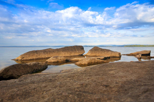 Stones in the water against the cloudy sky
