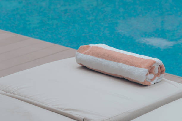 istock Roll soft towel on a sun bed near a swimming pool. 1170428234