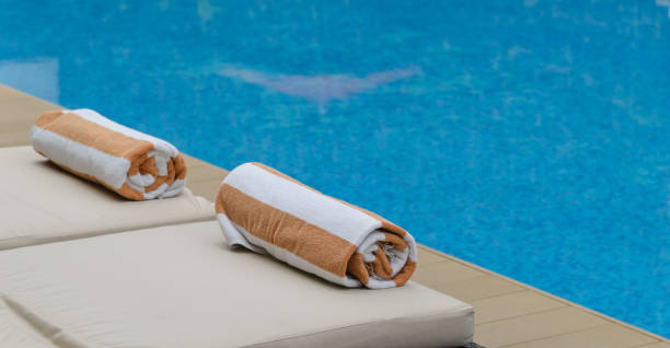 istock Roll soft towel on a sun bed near a swimming pool. 1170428274