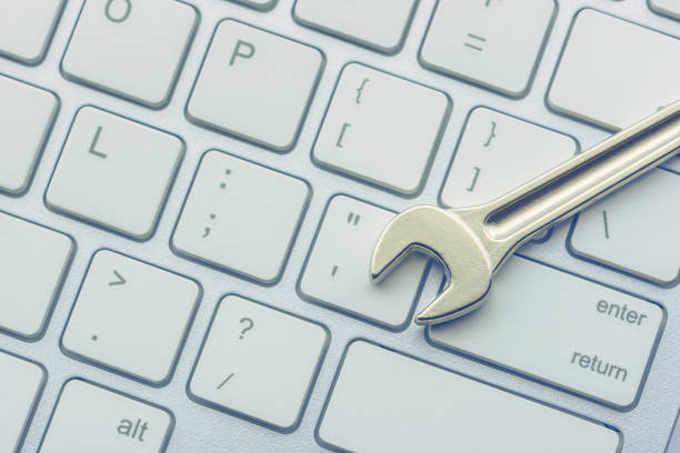 Computer hardware service and maintenance concept : Open-end wrench or spanner on a keyboard, depicts repairing / software setting and updating or changing to a newer version to improve performance concepto de mantenimiento y servicio de hardware informático: llave de extremo abierto o llave en un teclado, representa la reparación / configuración de software y la actualización o cambio a una versión más reciente para mejorar el rendimiento