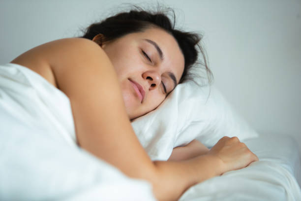 istock young pretty woman sleeping in bed with white sheets 1170440364