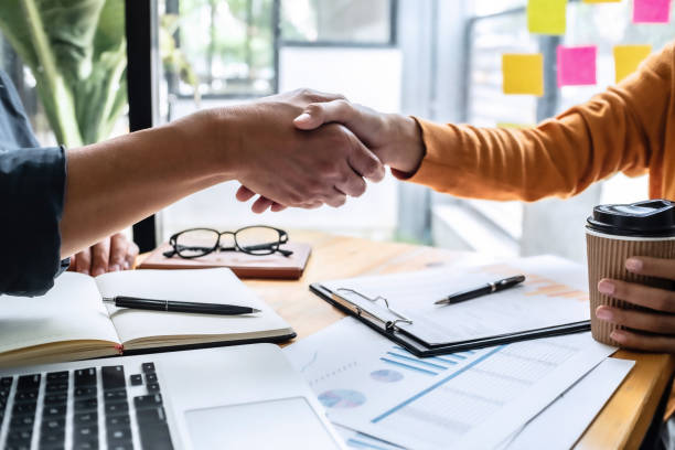 istock business man hands shaking together in office. 1170441344