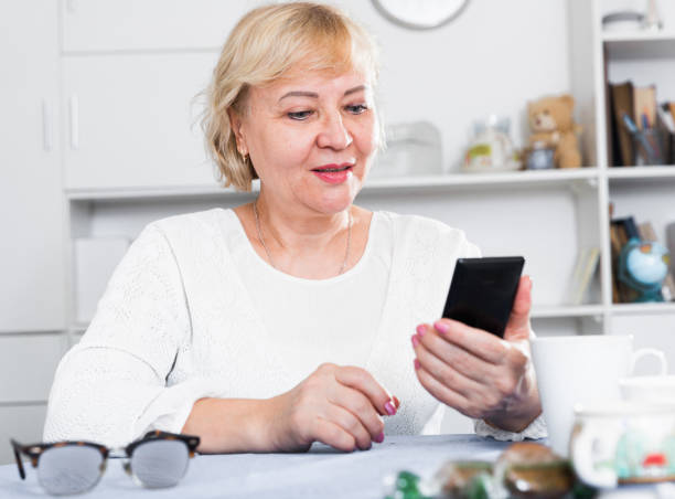 istock Mature woman with smartphone 1170444907