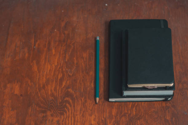 istock closed notebooks with pencil drawing on isolated wooden background 1170446146