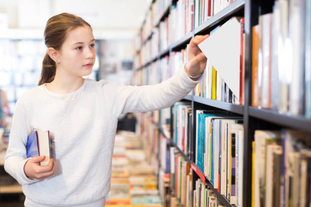 istock schoolgirl standing in library 1170447730