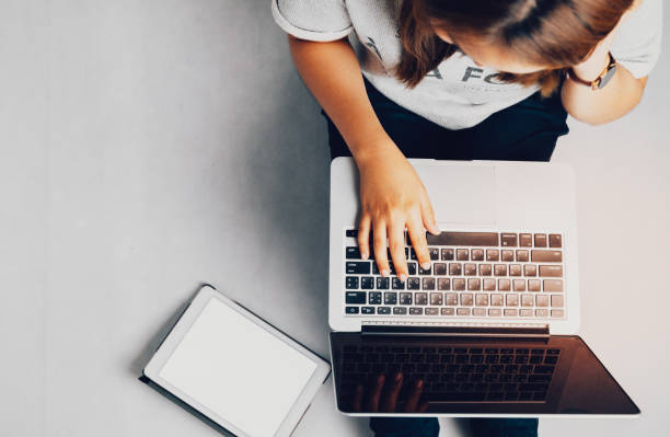 istock Young woman working on laptop computer while sitting on the floor and holding hot coffee, vintage tone. 1170449123