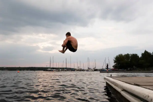 Cannonball: young man jumps into a lake, summer fun