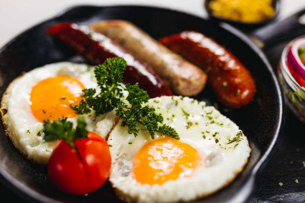 istock Fried eggs sunny side up served with sausage in a cooking pan 1170460698