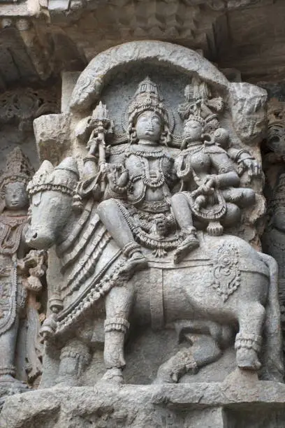 Ornate wall panel reliefs depicting Shiva-Parvati seated on Nandi, Kedareshwara temple, Halebidu, Karnataka, india.