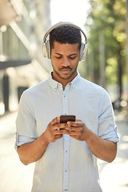 istock Hipster using headphones and phone on sidewalk 1170462310