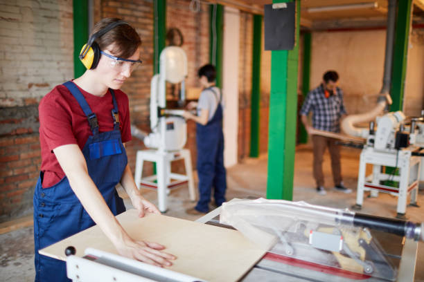 istock Young Worker Cutting Wood at Factory 1170466563
