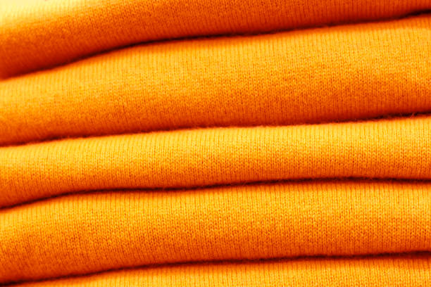 istock Stack of trend Dark Cheddar woolen sweaters close-up, texture, background 1170466571