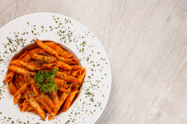 Penne pasta in tomato sauce with meat, tomatoes