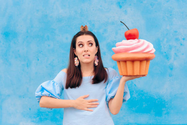 istock Birthday Woman Eating Cupcake Feeling Sick 1170466785