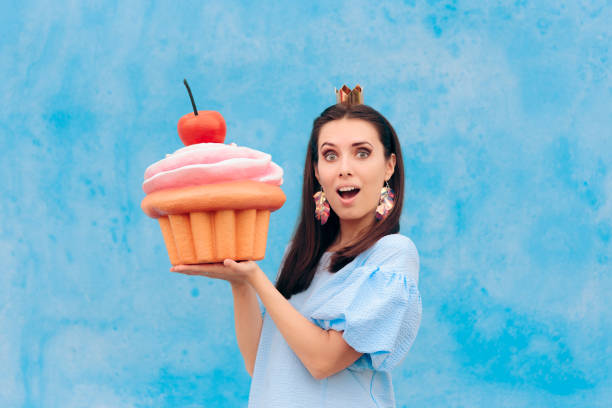 donna di compleanno che festeggia tenendo enorme cupcake - princess diet foto e immagini stock