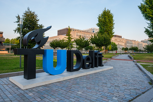 View on the campus of the Delft University of Technology, Netherlands and logo of the university.