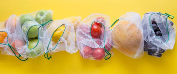 istock Fruits and vegetables in reusable eco-friendly mesh bags on bright yellow background. Zero waste shopping. Ecological concept. Stop pollution. 1170469317