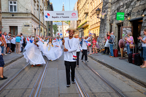 Panama Folklore group lead by banner bearer walking down streets during closing the Parade of Etnovyr Festival in street of Lviv. Lviv, Ukraine - August 25, 2019