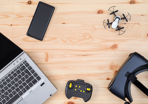 Top view of laptop, smartphone, vr glasses and drone on wooden table