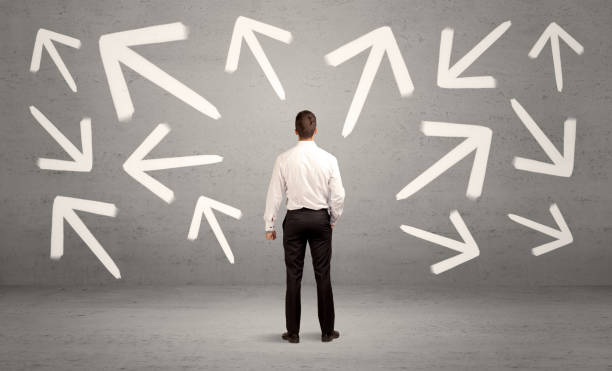 istock Confused salesman with arrows on wall 1170480415