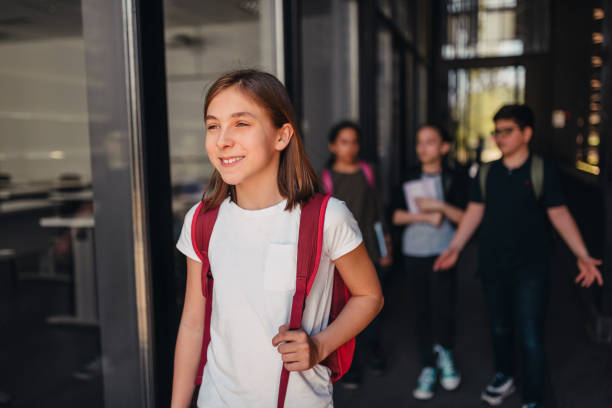 istock Girl going to the school with classmates 1170481810