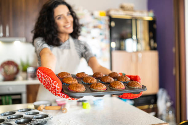 istock Smiling mother having fun with homemade muffins 1170481946