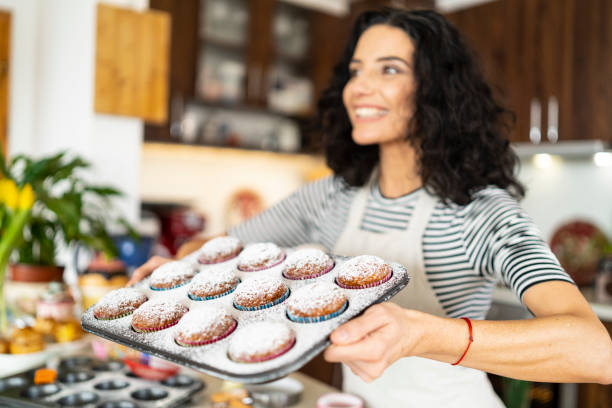 istock Smiling mother having fun with homemade muffins 1170481967