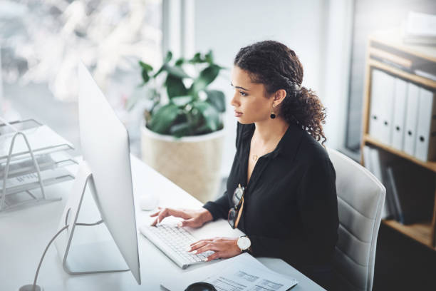 You'll succeed as long as you stay focused Shot of a young businesswoman working on a computer in an office small office interior stock pictures, royalty-free photos & images