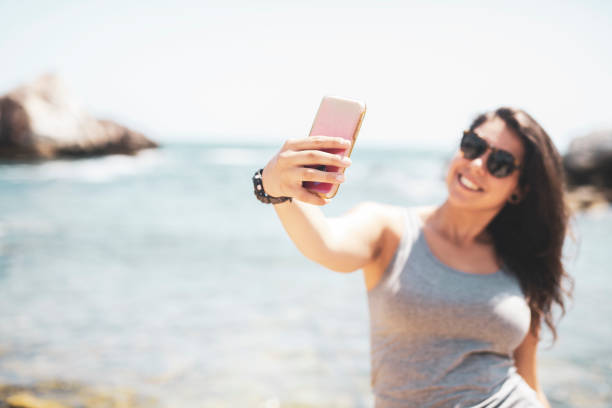 Beautiful woman making selfie on the summer beach.