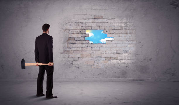 istock Business man hitting brick wall with hammer 1170482199