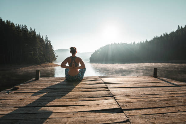 istock Woman practicing yoga at wild lake. 1170483420