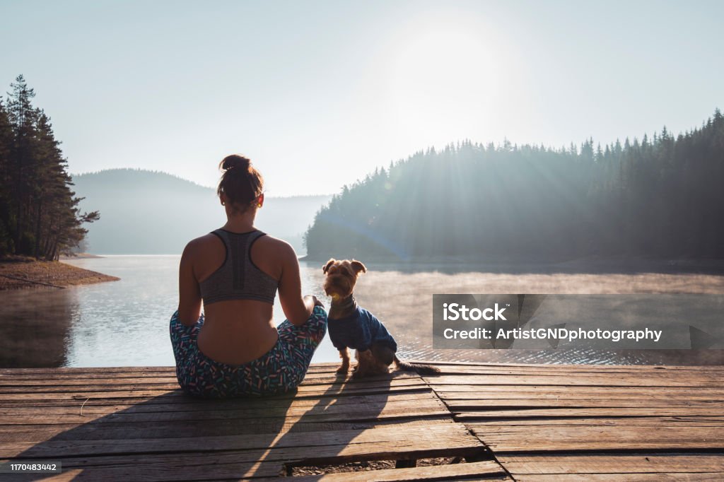 Frau, die Yoga am wilden See praktiziert. - Lizenzfrei Meditieren Stock-Foto