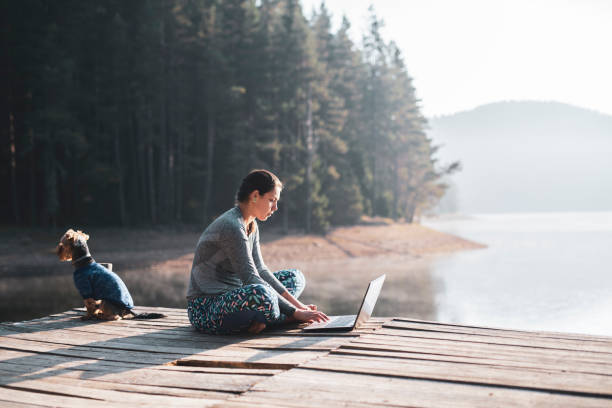 istock Beautiful woman using laptop in nature 1170483475