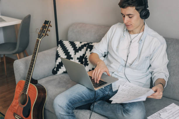 istock Young man learning to play the guitar from YouTube 1170485098