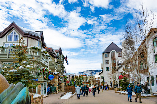 Vail, Colorado/USA-December, 30, 2018. Vail village,small town at base of Vail Mountain, gateway for winter sports.People walking next to stores, restarants, mountains in background.