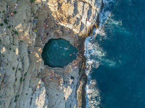 Giola is natural rock pool in Thasos island from Greece. People jumping to sea, fresh water fill this natural pool vie waves. This place is famous touristic place in Thasos.