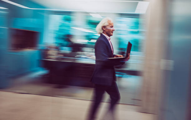istock Businessman Holding a Laptop, Walking Down The Hallway 1170492367