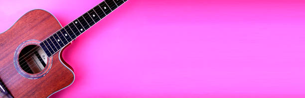 istock Acoustic guitar resting against a blank pink background with copy space 1170492465
