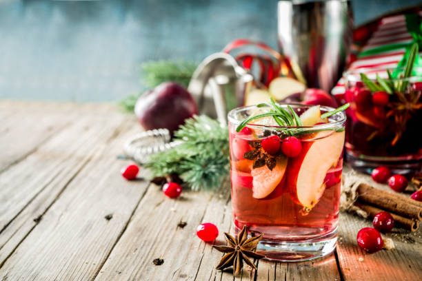 Winter hot sangria cocktail Winter hot sangria cocktail with red apples, wine, cranberry, rosemary and spices, christmas wooden background copy space mulled wine photos stock pictures, royalty-free photos & images