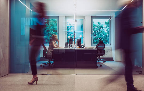 Empty office desk with paperwork and phone against a backdrop of files neatly arranged on shelving