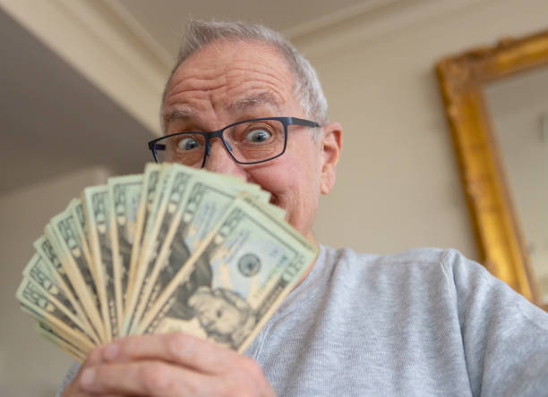 istock Happy senior man with money 1170497502