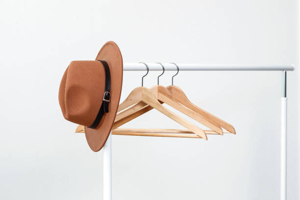 istock A brown hat and hangers hangs on a counter near a white wall. 1170497960