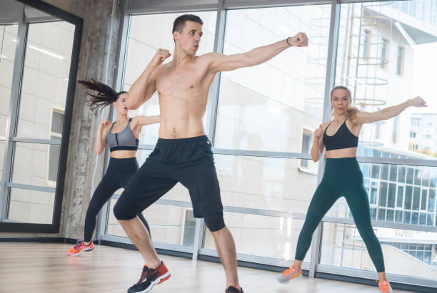 istock Fitness training in the studio - two young women training with their coach 1170499207