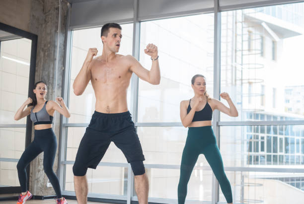 istock Fitness training in the studio - two young women training with their athletic coach - boxing 1170499253
