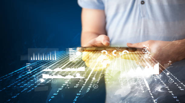 istock Hand holding touchpad tablet with business market graphs 1170500087