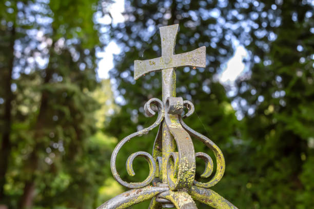 A metal cross with ornaments on a railing in the park